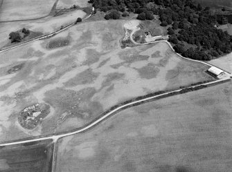 Oblique aerial view centred on the cropmarks of the unenclosed settlement, circular enclosure, ring ditch and pits at Monboddo, looking to the NE.