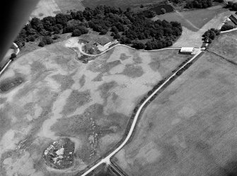 Oblique aerial view centred on the cropmarks of the unenclosed settlement, circular enclosure, ring ditch and pits at Monboddo, looking to the SE.