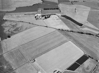 Oblique aerial view centred on the cropmarks of the enclosed settlement, ditch defined cursus, enclosure, ring ditches, barrows, pits and rig with the farmstead adjacent, looking to the WSW.