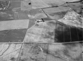 Oblique aerial view centred on the cropmarks of a circular enclosure at Myreside with the farmstead adjacent, looking to the S.