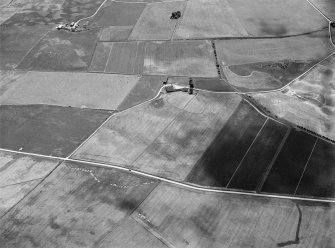 Oblique aerial view centred on the cropmarks of a circular enclosure at Myreside with the farmstead adjacent, looking to the SSE.