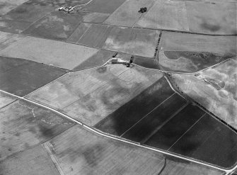 Oblique aerial view centred on the cropmarks of a circular enclosure at Myreside with the farmstead adjacent, looking to the ESE.