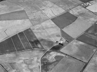 Oblique aerial view centred on the cropmarks of a circular enclosure at Myreside with the farmstead adjacent, looking to the NNE.