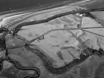 Oblique aerial view centred on the cropmarks of the unenclosed settlement, barrow cemetery, enclosure, souterrain, pits and rig at Red Castle and West Mains, looking to the ESE.