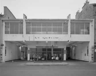 Scanned copy of general view of the whole front of the filling station in use but with the upper floor in disrepair, seen from Causewayside from the West.