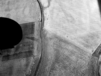 Oblique aerial view of the cropmarks of the unenclosed settlement at Newbarns, looking to the NW.