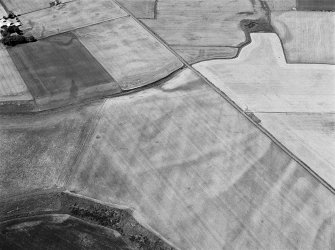 Oblique aerial view of the cropmarks of the unenclosed settlement at Newbarns, looking to the W.