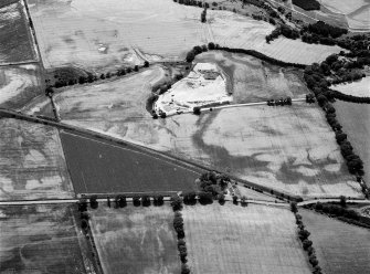 Oblique aerial view centred on the cropmarks of the unenclosed settlement, ring ditches, souterrain, pit alignment, and linear features at Arrat's Mill, looking to the SW.