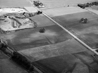 Oblique aerial view centred on the cropmarks of the ring ditches and pit alignment at Fullerton, looking to the S.