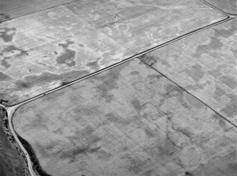 Oblique aerial view centred on the cropmarks of the square barrow, roundhouses, subrectangular buildings, ring ditch and pits at Kinchyle and Little Kildrummie, looking to the WSW.