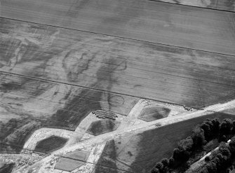 Oblique aerial view centred on the cropmarks of the enclosure and the former airfield at Brackla House, looking to the WSW.

