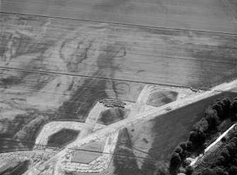 Oblique aerial view centred on the cropmarks of the enclosure and the former airfield at Brackla House, looking to the WSW.