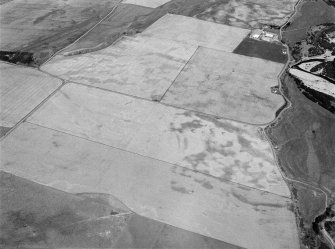 Oblique aerial view centred on the cropmarks of the square barrow, roundhouses, subrectangular buildings, ring ditch and pits at Kinchyle and Little Kildrummie, looking to the NNE.