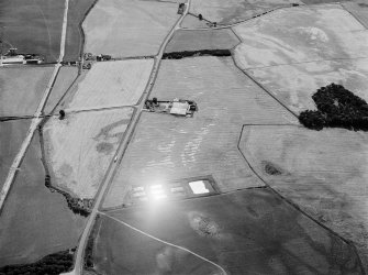 Oblique aerial view centred on the cropmarks of the roundhouses, ring-ditches, long barrow and pits at Mains of Struthers and Newmill, looking to the WSW.