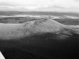 Oblique aerial view centred on the remains of the vitrified fort at Tap O' Noth, looking to the SSE.