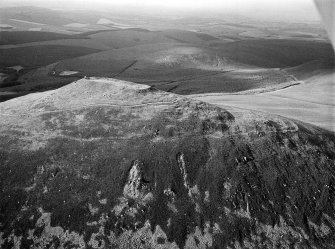 Oblique aerial view centred on the remains of the vitrified fort at Tap O' Noth, looking to the NW.