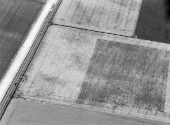 Oblique aerial view centred on the cropmarks of the souterrains and possible enclosure at Upper Powburn, looking to the NNE.