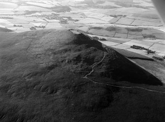 Oblique aerial view centred on the remains of the vitrified fort at Tap O' Noth, looking to the SE.