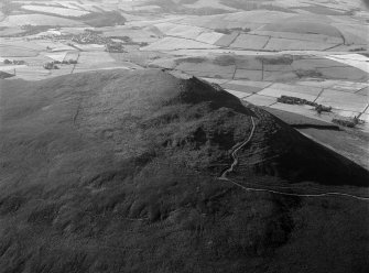 Oblique aerial view centred on the remains of the vitrified fort at Tap O' Noth, looking to the SE.