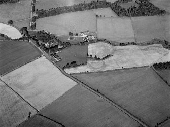 Oblique aerial view centred on the remains of the possible henge or moated site at Roundabout, looking to the NW.