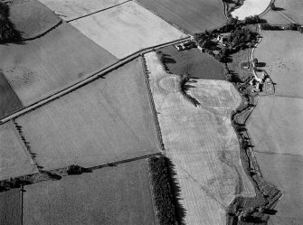 Oblique aerial view centred on the remains of the possible henge or moated site at Roundabout, looking to the SW.