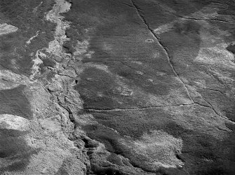 Oblique aerial view centred on the remains of enclosures, buildings and rig at Burn of Allanstank, looking to the SW.