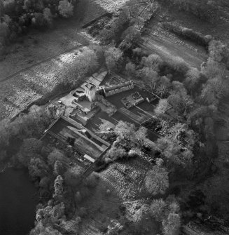 Oblique aerial view centred on the remains of Mugdock castle, chapel and tower, taken from the NE.