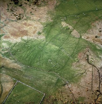 Oblique aerial view centred on the remains of the farmsteads, field system and burnt mounds, taken from the SE.