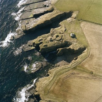 Oblique aerial view of the commemorative monument and the remains of Nybster broch, taken from the N.