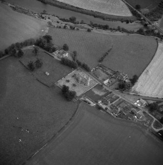 Oblique aerial view centred on church from NW.