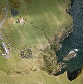 Oblique aerial view centred on the house, curing yard, watermill, steps and fishing station with farmsteads adjacent, taken from the SW.