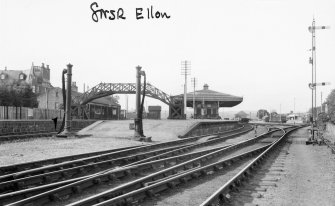 General view from trackside, showing footbridge and station buildings.