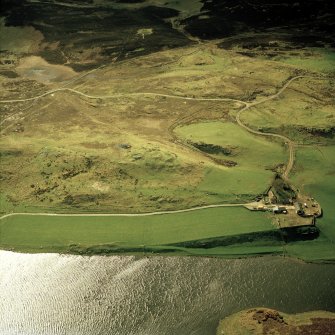 Oblique aerial view centred on the remains of the broch and cairn, taken from the ESE.