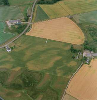 Oblique aerial view centred on the cropmarks of the possible pit-defined enclosure, pits, linear cropmarks and promontory fort with church, mausoleum and cemetery adjacent, taken from the WSW.