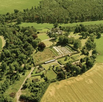 Oblique aerial view centred on the country house with walled and terraced gardens, stables and laundry adjacent, taken from the N.
