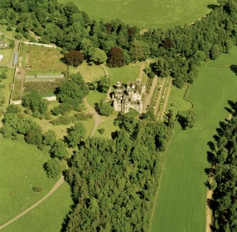 Oblique aerial view centred on the country house with walled and terraced gardens adjacent, taken from the W.