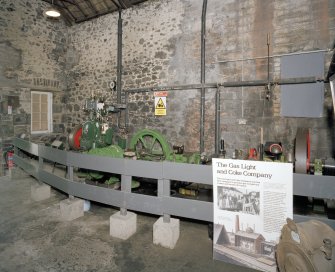 Interior. Coal Store: View of the former retort house and coal store in use as an exhibition space, and various artefacts brought from other sites. Sisson high speed engine to left and waller exhauster and steam engine in middle of image