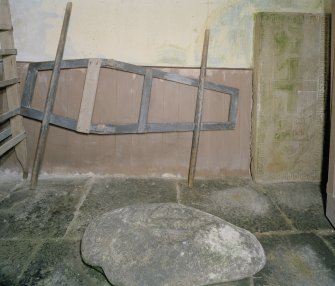 Interior. View of lobby with stone slab and coffin carrying frame