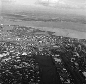 General oblique aerial view looking over the oil refinery across the River Forth towards Fife, taken from the W.
