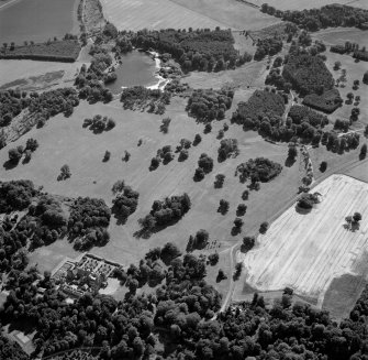 Oblique aerial view centred on the cropmarks of avenues leading to the country house, taken from the NNE.