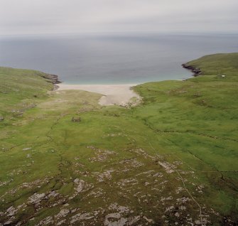 Mingulay, oblique aerial view centred on the remains of the chapel house and enclosure with the remains of the township, chapel and graveyard and the school and schoolroom adjacent, taken from the WNW.