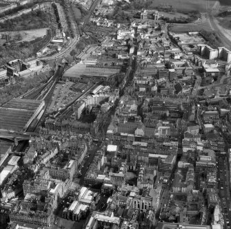 Oblique aerial view of centre of Edinburgh including Holyrood Palace at top of photograph, Chamber Street at right, St Giles' Cathedral at bottom and Waverley Station and St Andrew's House at left