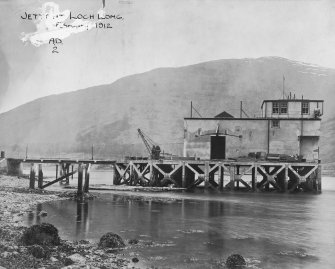 Scanned image of photograph showing pier head building including part of the pier and a small crane from NW.
Titled 'Jetty at Loch Long'.