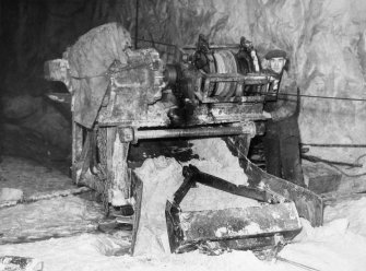 Scanned copy of view of scrape or slusher bucket face cleaning equipment underground.