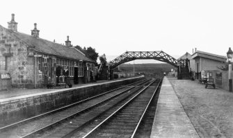 Scanned image of photograph showing Grantown-on-Spey (East) station with main up platform building, footbridge and down platform shelter from S.