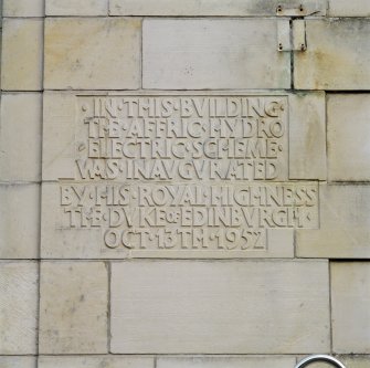 Detail of commemorative plaque to left of main entrance on W facade of Fasnakyle Power Station.