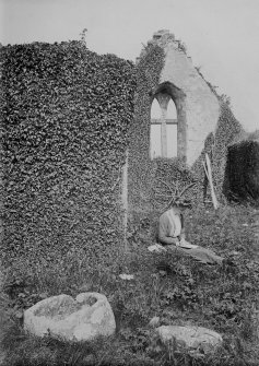 Digital copy of general view of interior of Durness old parish kirk, looking from the N aisle towards the E gable. A lady is seated, reading, in the middle ground. The old font lies in the foreground.
From photographic print included in A O Curle's 'Sutherland' journal (MS 36/9, loose at page 88).