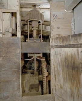 Interior. Ground floor. Main  milling area (W part of structure). Gear cupboard showing bevel pit wheel wallower and great spr wheel and the grinding stones stone nut.