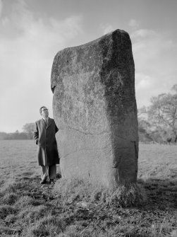 Scanned image of view of standing stone from south-east, with Mr Alastair Maclaren (RCAHMS).