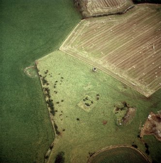 Oblique aerial view centred on the remains of the recumbent stone circle and dovecot, taken from the NW.